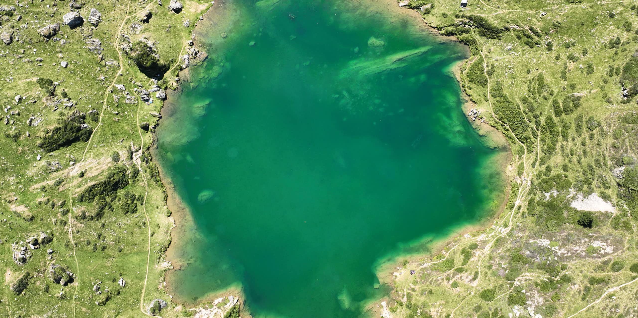aerial view of a green mountain lake