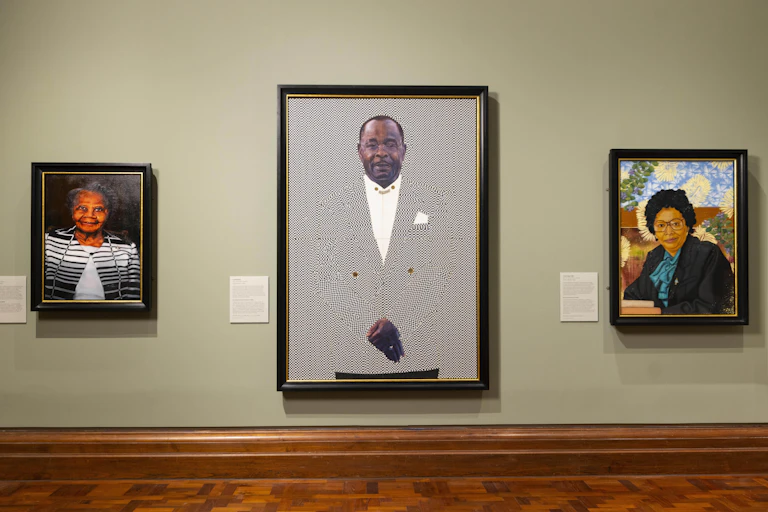 Three paintings of Windrush generation on display at the exhibition.