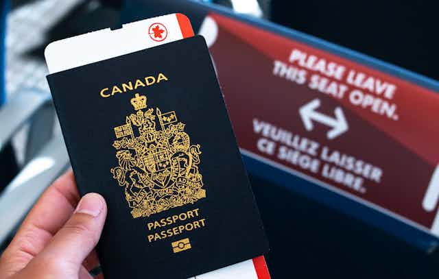 A hand holding a Canadian passport