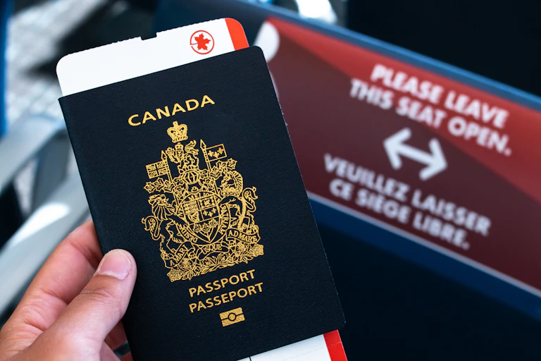 A hand holding a Canadian passport