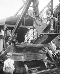 Roosevelt sits in the cab of a large steam shovel
