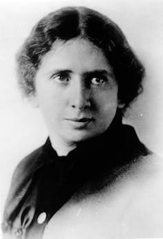 A close-up formal portrait of a woman with dark hair in a black and white photograph.