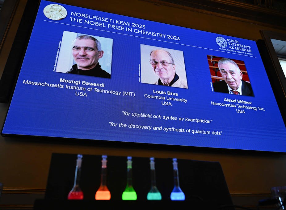 Nobel Prize announcement slide with glowing flasks in the foreground