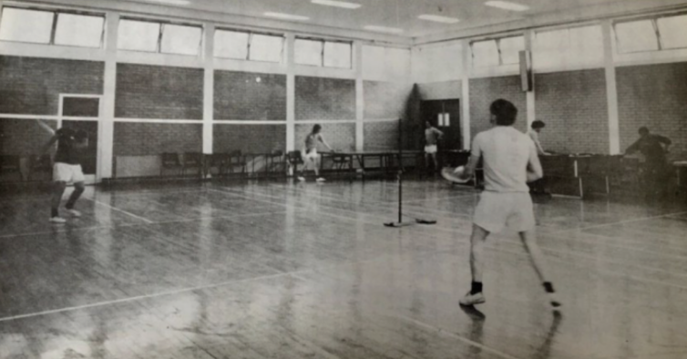 A black and white archival photograph of people playing sport indoors.