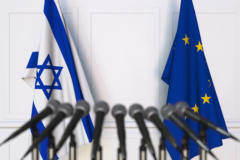 EU and Israeli flags behind a row of microphones.