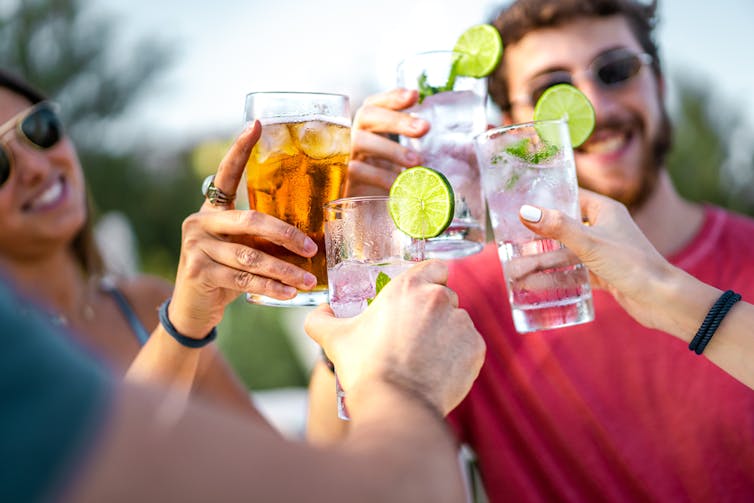 Friends drinking alcohol, clinking glasses, outside