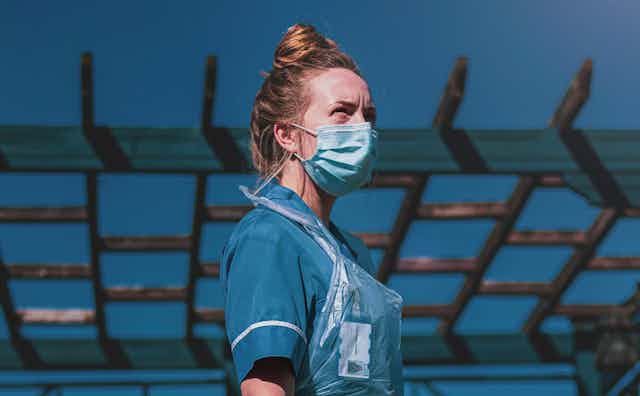 Nurse in PPE looks into the sky