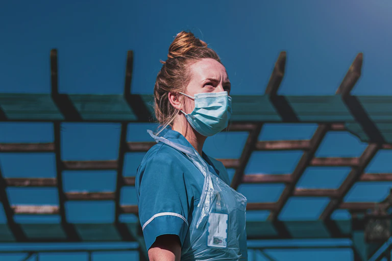 Nurse in PPE looks into the sky