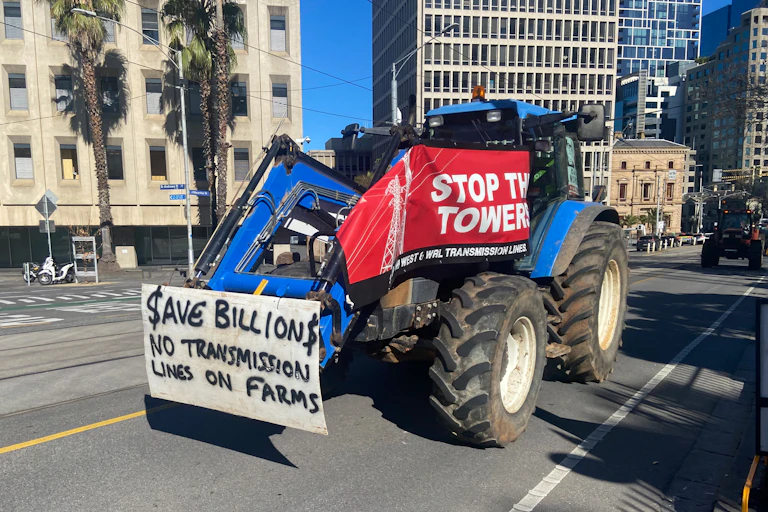 A tractor descends on Victoria's Parliament House as farmers protest against a decision to site electricity transmission lines on their land.