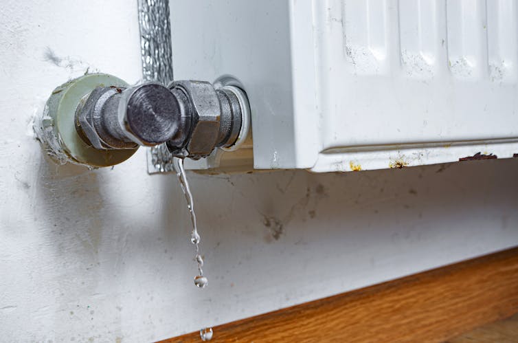 A leaking old rusty radiator in a home.