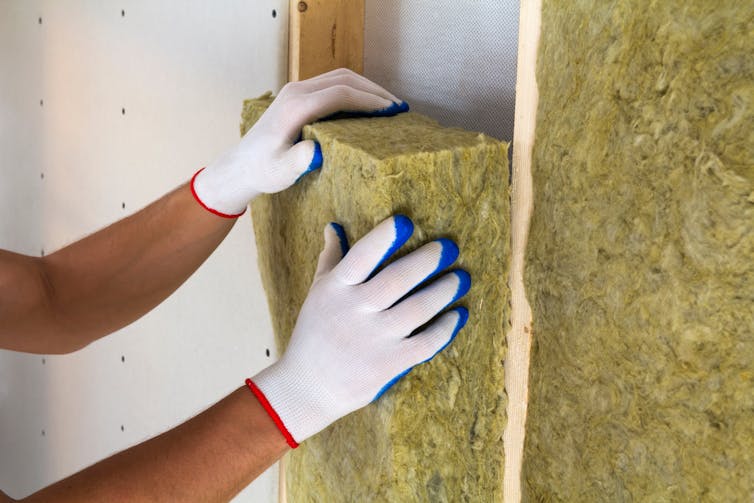 Close-up of worker hands in white gloves insulating.