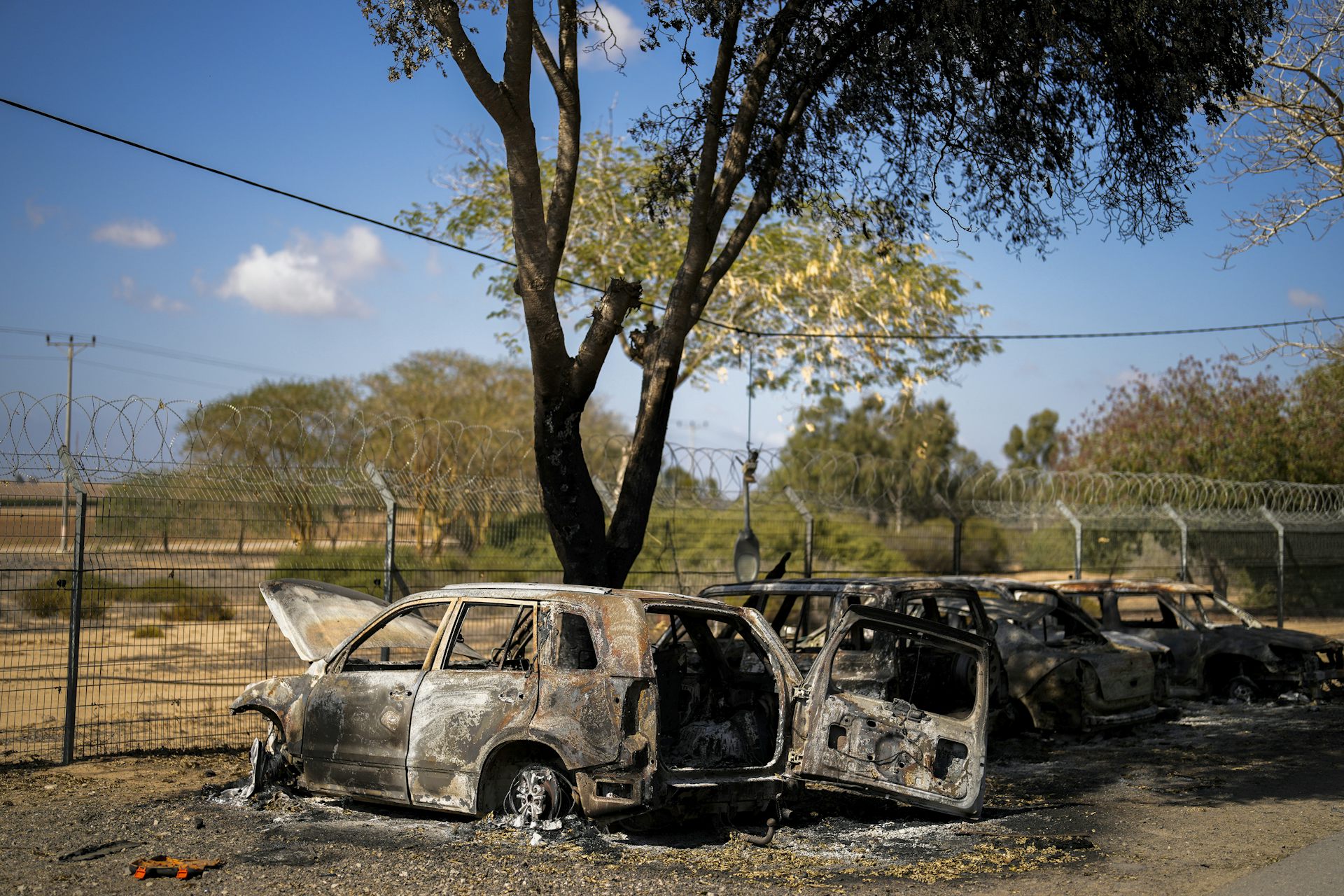 Images de voitures calcinées au bord d'une clôture dans un champ