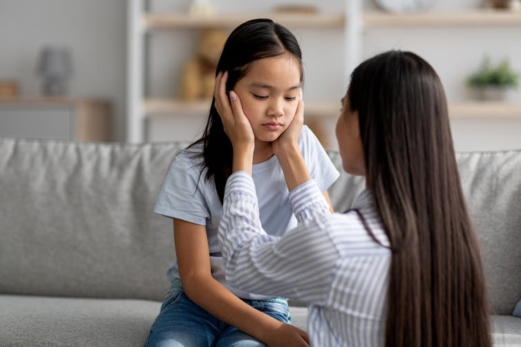 A young girl being comforted by her mother