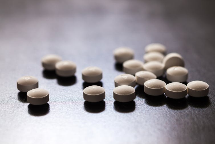 A number of round, white pills on a table.