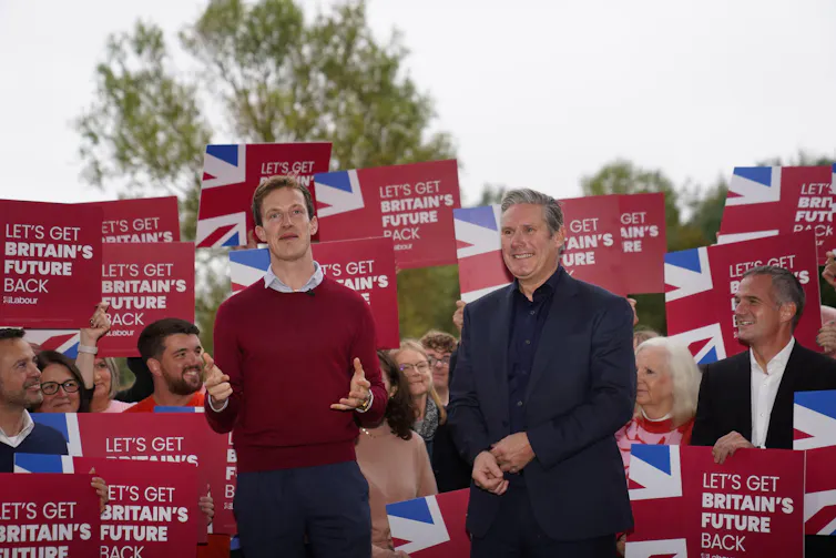 Alistair Strathern and Keir Starmer standing in front of supporters holding placards.