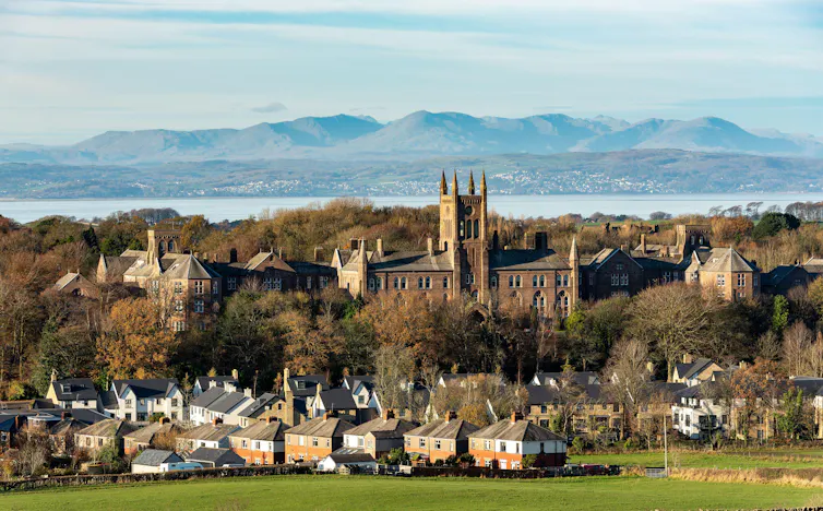 How to Solve Our Mental Health Crisis By Matthew Smith View of a former asylum with lake and hills in the background.