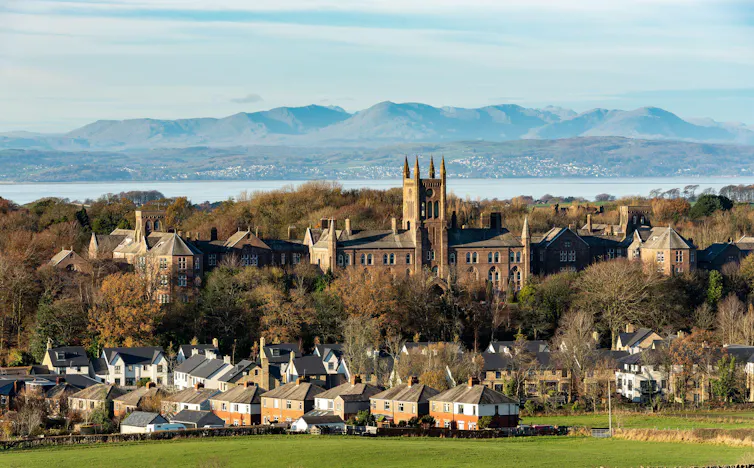View of a former asylum with lake and hills in the background.