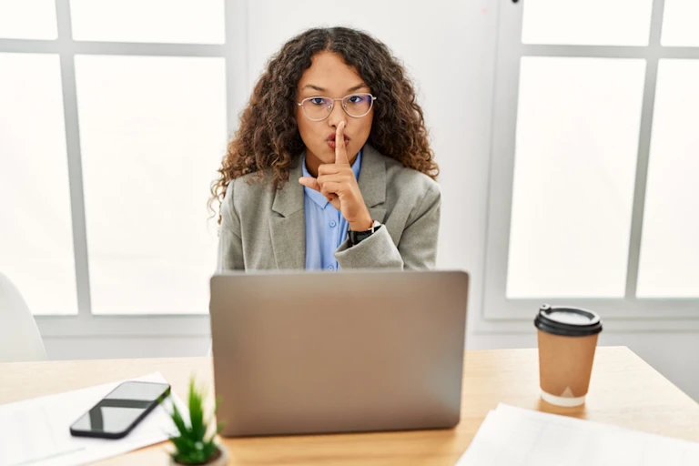 Jeune femme demandant du silence au bureau