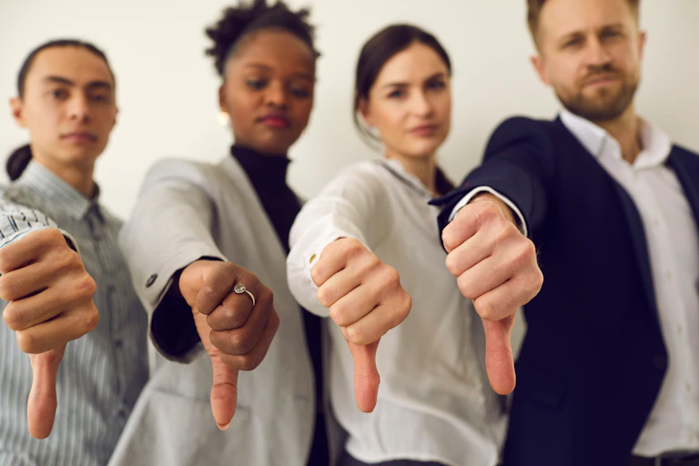 Four people with thumbs down.