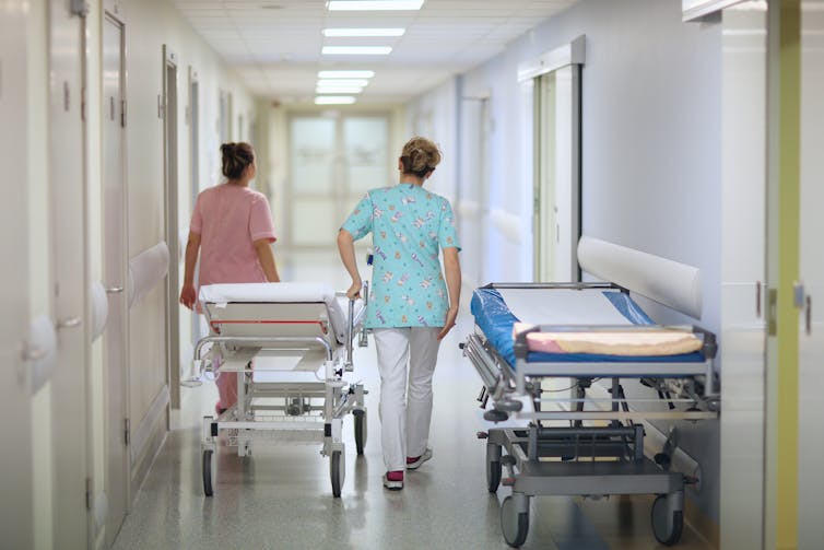 Health-care workers pushing a gurner in a hospital corridor