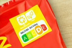 Détail d’un paquet de chips affichant le logo Nutri-Score à côté d’autres logos