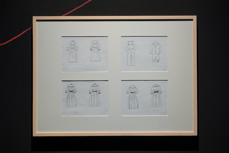 Framed image on a wall showing four panes of uniforms, all under white matting.