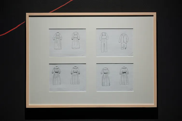 Framed image on a wall showing four panes of uniforms, all under white matting.