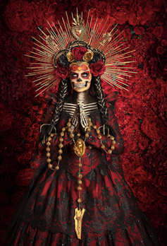 Extravagent costume featuring a headdress skull mask and red and black cloak