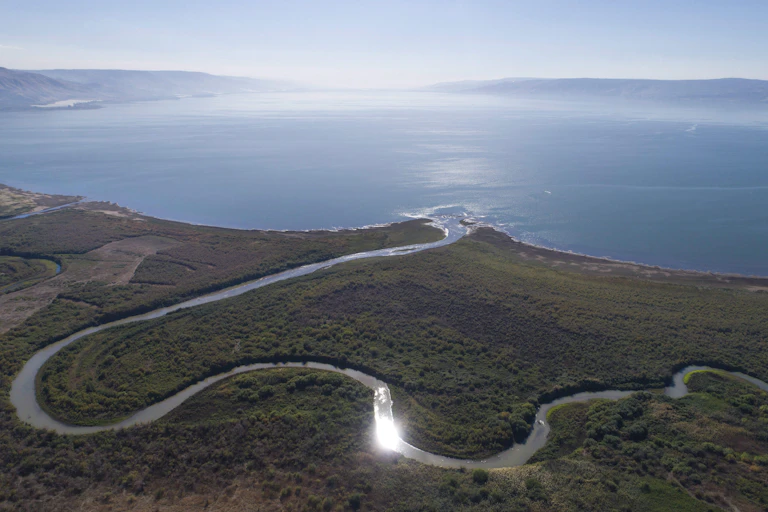 An aeriel view of a river flowing into the sea.