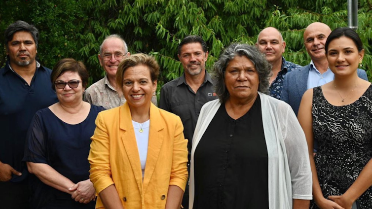 A group of nine people posing for a photograph.