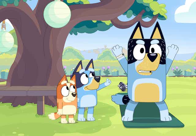 Bluey and Bingo watch their dad exercise under a tree.