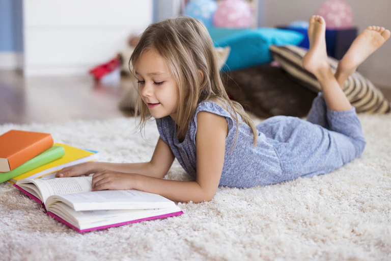 Petite fille plongée dans la lecture d'un livre