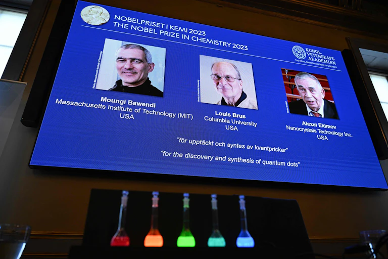 Nobel Prize announcement slide with glowing flasks in the foreground
