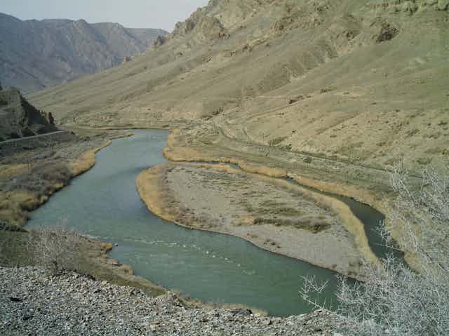 Fotografía de un río al que van a dar dos formaciones montañosas.