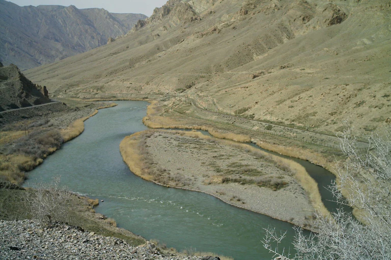 Fotografía de un río al que van a dar dos formaciones montañosas.
