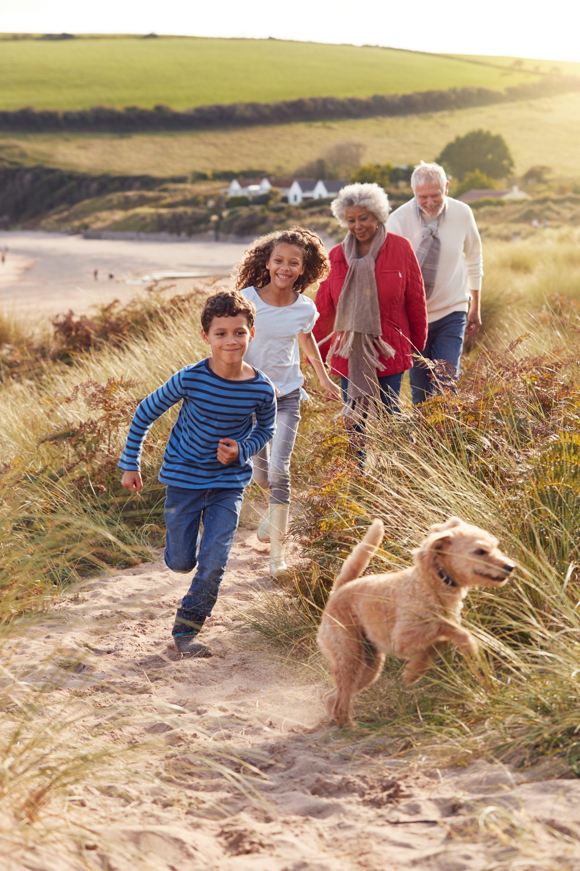 Photo d’une famille en promenade en bord de mer, avec un jeune chien.