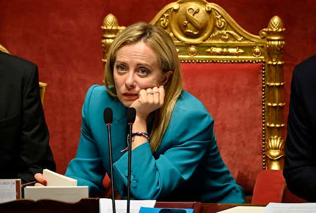 Giorgia Meloni looking downcast in parliament. 