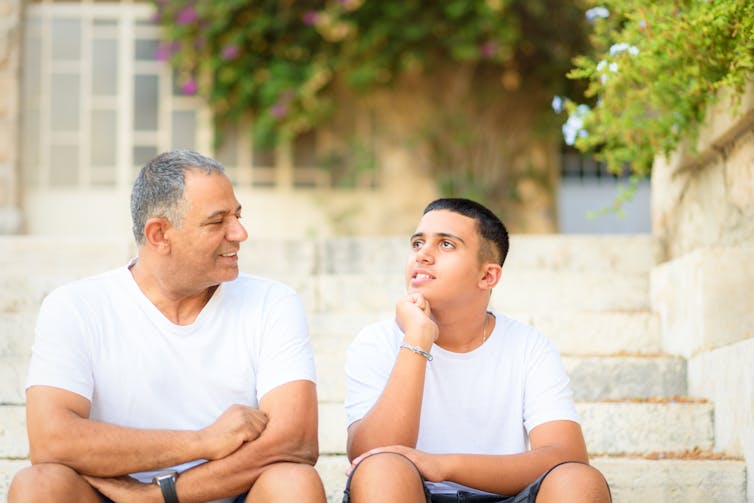 A dad talking with a teen.