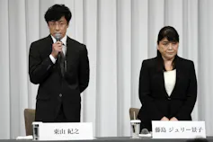 A man and woman seen at press conference.