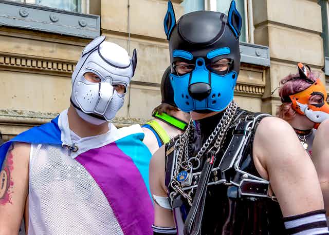 Two men wearing pup costumes. 