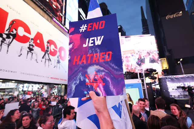 A sign that says 'End Jew Hatred' being held aloft at a rally.