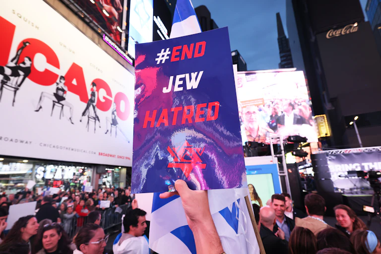 A sign that says 'End Jew Hatred' being held aloft at a rally.