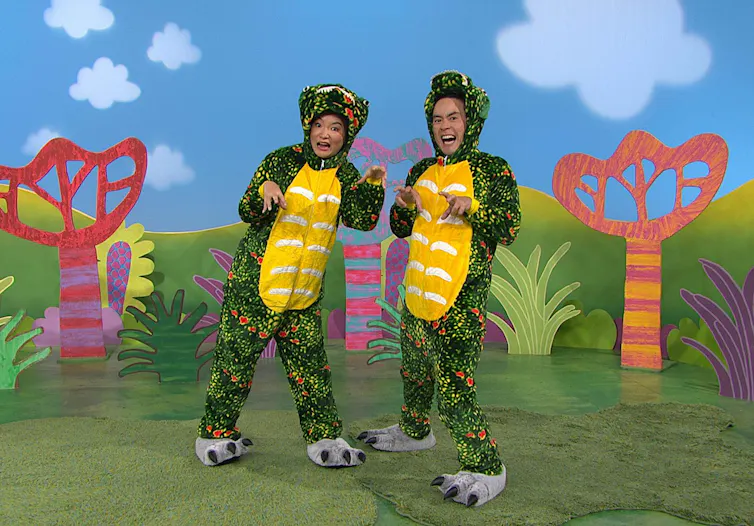 Two Play School presenters are dressed as furry dinosaurs