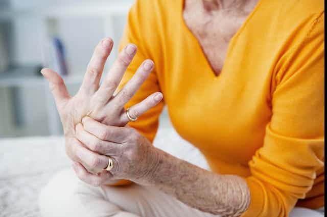 A woman appears to have pain in her hand.