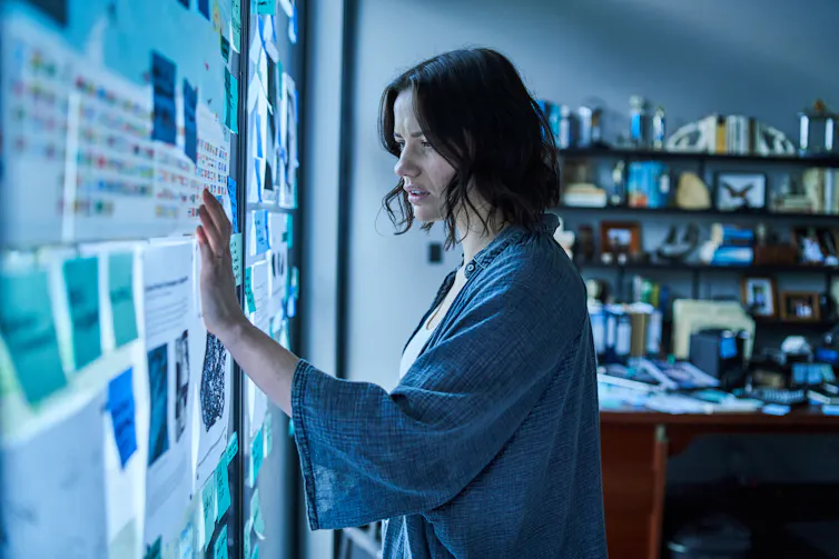 Woman looking at text pinned to the wall