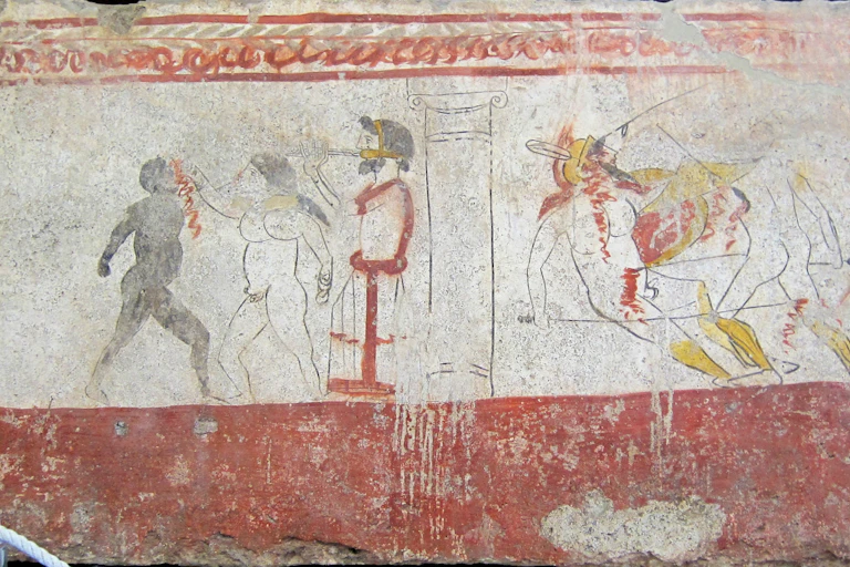Juegos de gladiadores (a la derecha un combate armado, y a la izquierda un combate de boxeo entre un blanco y un negro al son del aulós) en honor de un difunto.