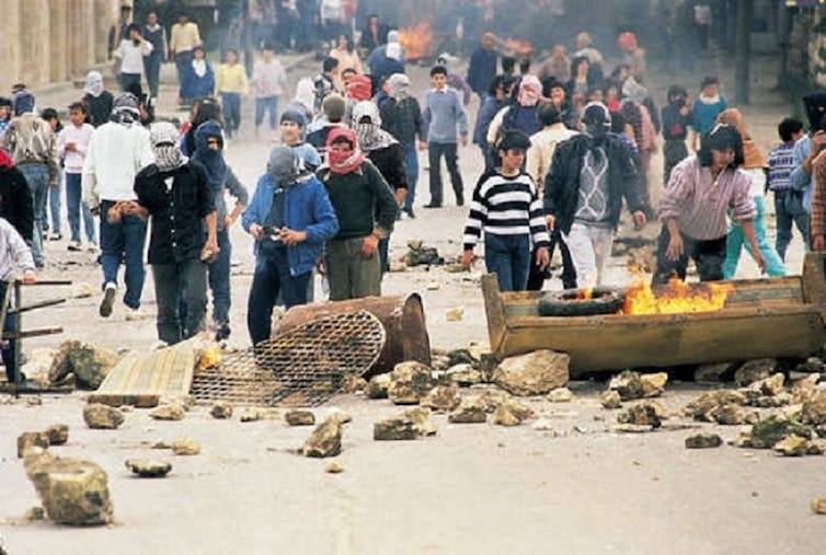 Jovens palestinos fazendo barricadas de rua em Gaza durante a primeira intifada de 19087 a 1993