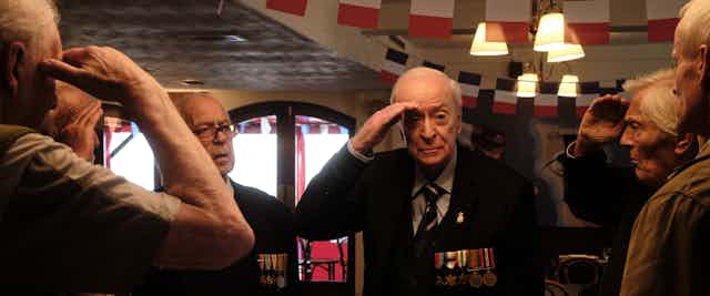 Caine in military medals saluting