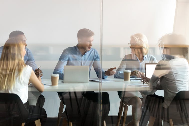 A group of people having a conversation in a conference room