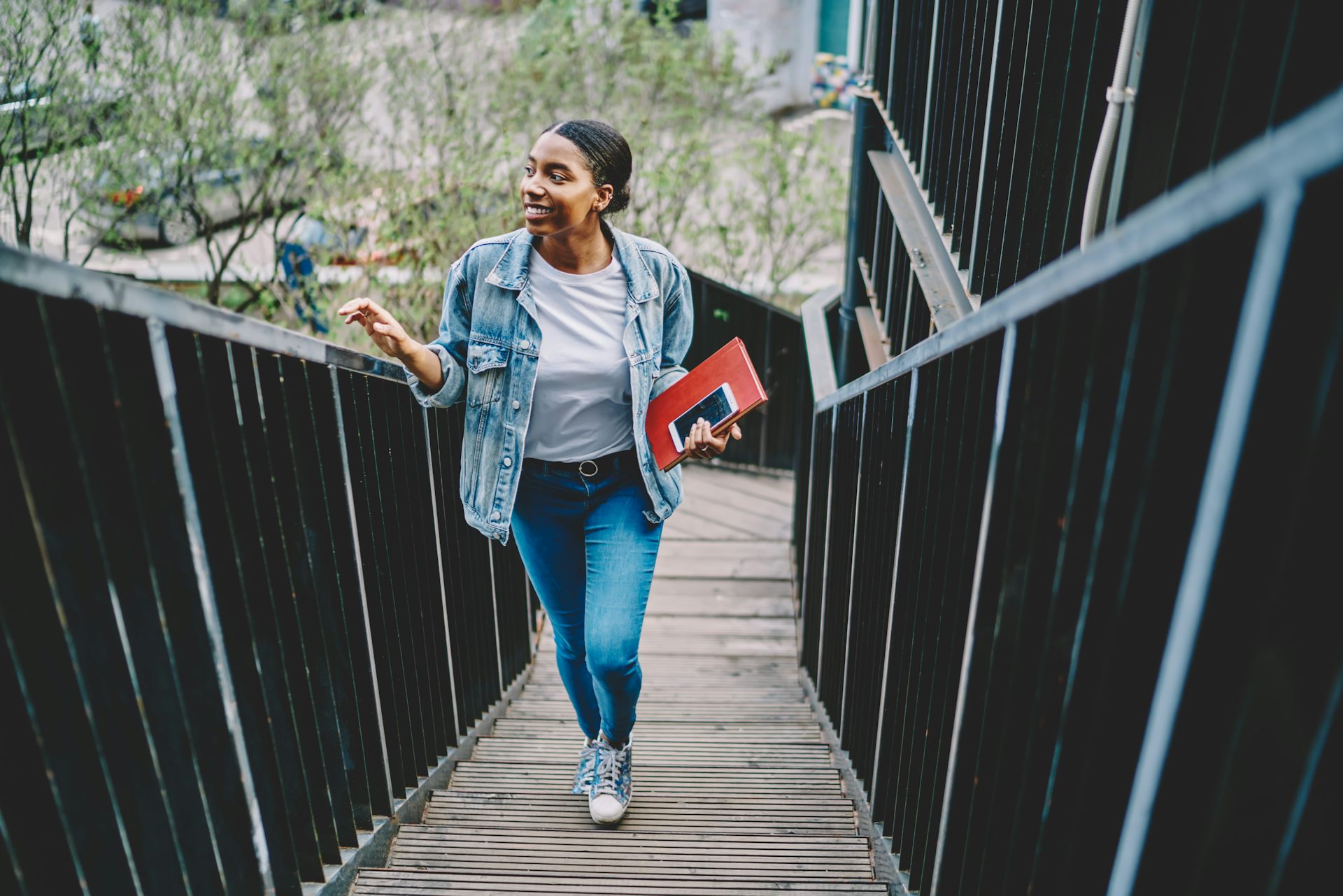 A young woman ascending a staircase outdoors.
